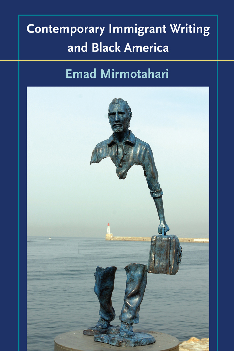 A metal statue of a man with his torso missing stands on a rock. Through him, the ocean is visible.