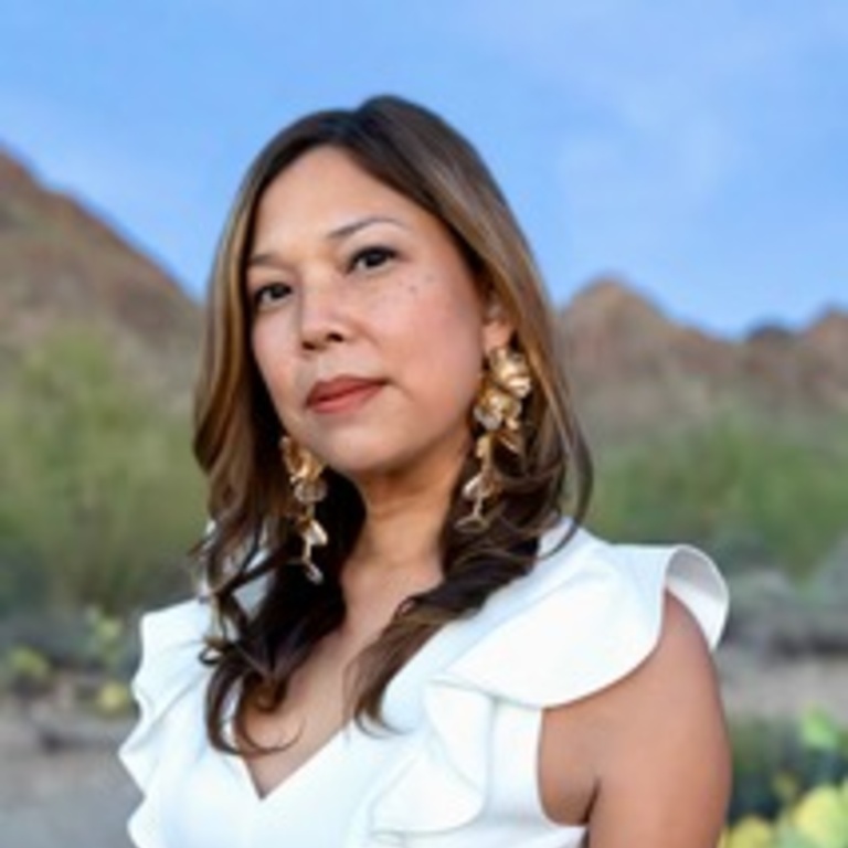 A person with long hair and a white dress stands in a desert biome.